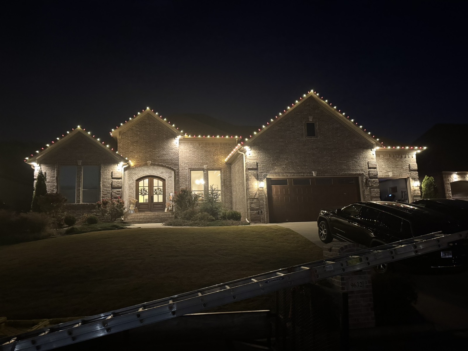 Red and green C9 roofline lighting on a Central Arkansas home at night