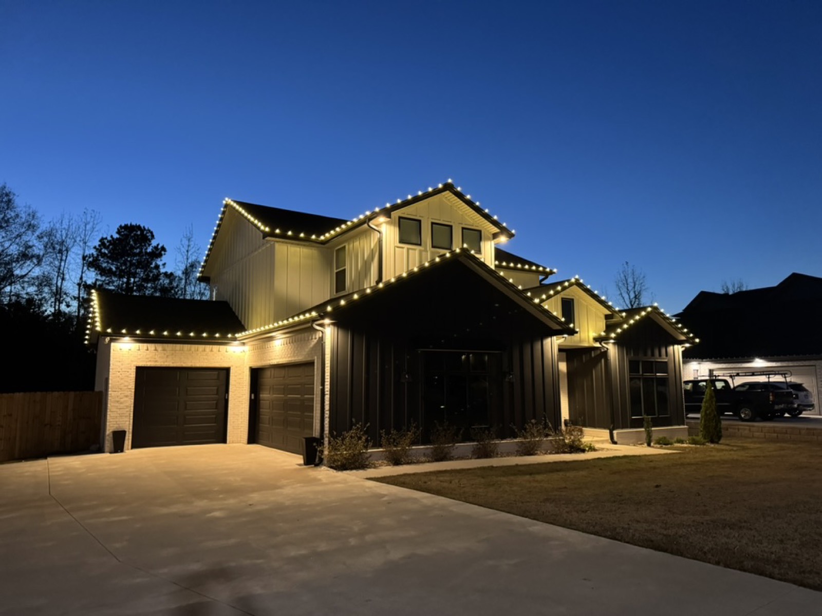 Modern farmhouse with roofline lighting at twilight